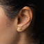 a close up of a person's ear wearing a gold earring