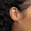 a close up of a person's ear with a gold earring