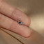 a person's hand holding a tiny silver bird ring