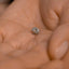 a close up of a person's hand holding a ring