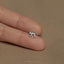 a person's hand holding a tiny silver elephant ring
