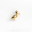 a gold bird brooch sitting on top of a white surface