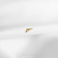 a single gold earring on a white surface