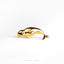 a gold plated dolphin ring on a white background