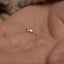 a tiny gold nose ring on someone's hand
