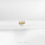 a gold heart pin sitting on top of a white cloth