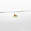 a pair of gold earrings sitting on top of a white surface