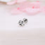 a pair of silver earrings sitting on top of a table
