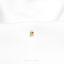 a close up of a gold pin on a white shirt