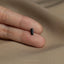 a person's hand holding a small black object