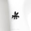 a black spider brooch sitting on top of a white napkin