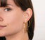 Model wearing stacked hoops in large, medium, and small sizes from Shemisli's hoop collection.