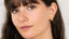 Gold huggie hoop earrings worn on ear