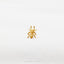 a gold spider ring sitting on top of a white sheet