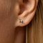 a close up of a person wearing a pair of earrings