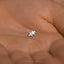 a person&#39;s hand holding a tiny silver puzzle piece