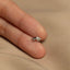 a person&#39;s hand holding a tiny silver ring