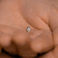 a tiny diamond ring sitting on the palm of someone&#39;s hand