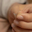 a person holding a tiny ring with a tiny bird on it