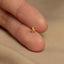 a person&#39;s hand holding a tiny gold star ring