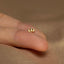 a person&#39;s finger with a tiny gold ring on it