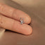 a person&#39;s hand holding a tiny silver nose ring