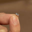 a person holding a tiny ring in their left hand