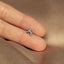 a person&#39;s hand holding a tiny silver star ring