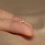 a person&#39;s hand with a tiny gold ring on it