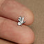 a person&#39;s finger with a tiny silver bird ring on it