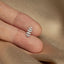 a person&#39;s hand holding a tiny silver leaf charm