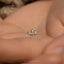 a person's hand holding a tiny triangle shaped ring