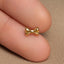 a close up of a person wearing a gold bow ring