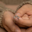 a close up of a person's hand holding a ring