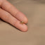 a person's hand holding a tiny gold ring