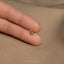 a person's hand holding a tiny gold ring