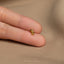 a person's hand holding a tiny gold ring