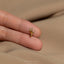a person&#39;s hand holding a tiny gold bird ring