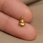 a small gold christmas tree charm on a finger