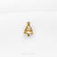 a gold christmas tree pin on a white surface