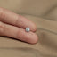 a person's hand holding a small diamond