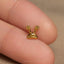 a close up of a person&#39;s finger with a small gold snail charm on