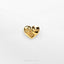 a gold heart shaped object on a white surface