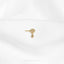 a close up of a white shirt with a gold brooch