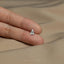 a person's hand holding a tiny silver object