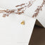 a pair of earrings sitting on top of a white box