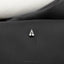 a silver sailboat pin sitting on top of a black chair