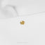 a close up of a gold earring on a white shirt