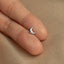 a person&#39;s hand with a small silver ring on it