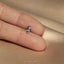 a person&#39;s hand holding a tiny silver horse ring